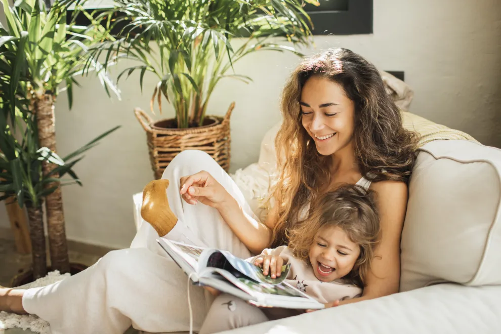Una mamá y su hija hojeando juntas un libro