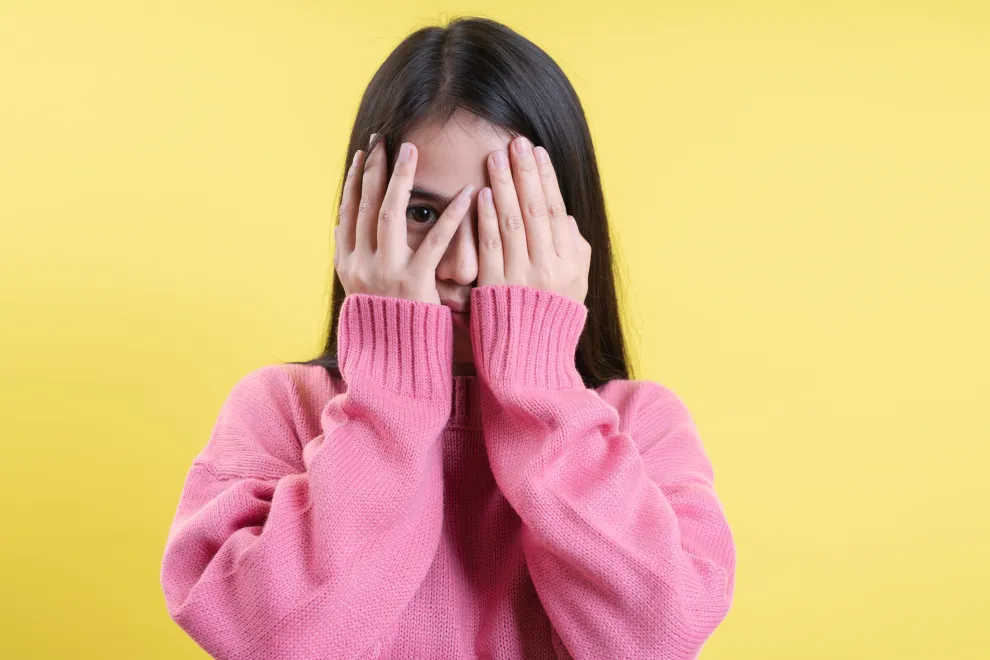Foto de mujer tapándose los ojos.